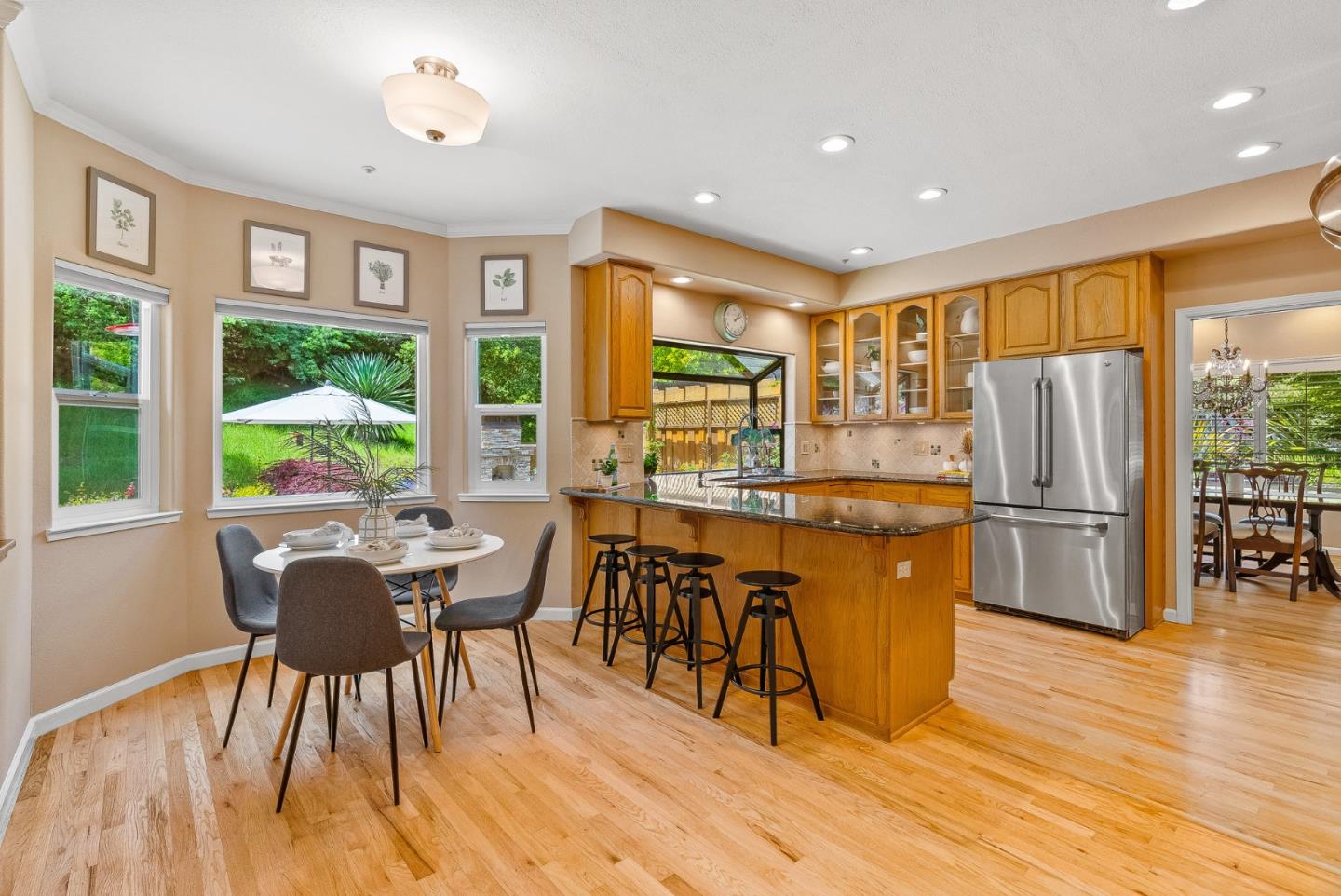 125 Chase Lane Aptos, CA 95003 - Photo 4 of 34 a kitchen with stainless steel appliances granite countertop a stove a refrigerator a dining table and chairs with wooden floor