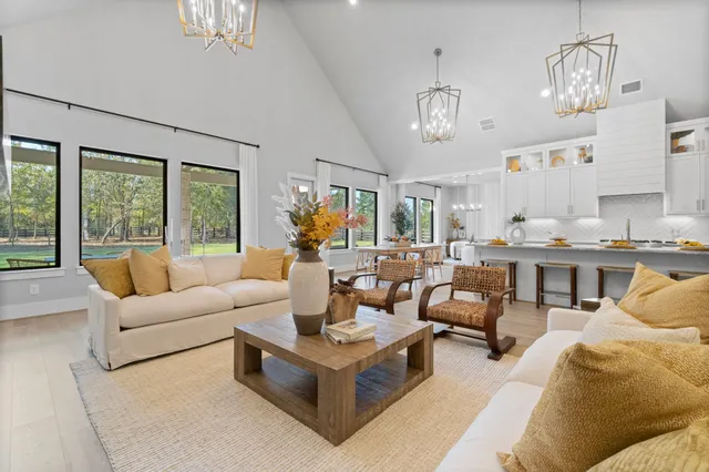 a living room with furniture kitchen view and large windows