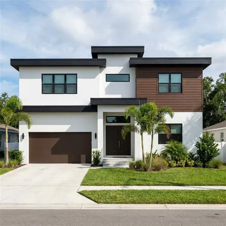a front view of a house with a garden and garage