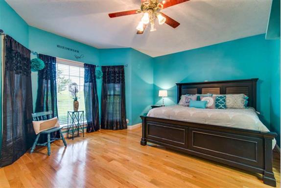 7768 Webster Road White House, TN 37188 - Photo 19 of 30 a bedroom with a large bed and a chandelier