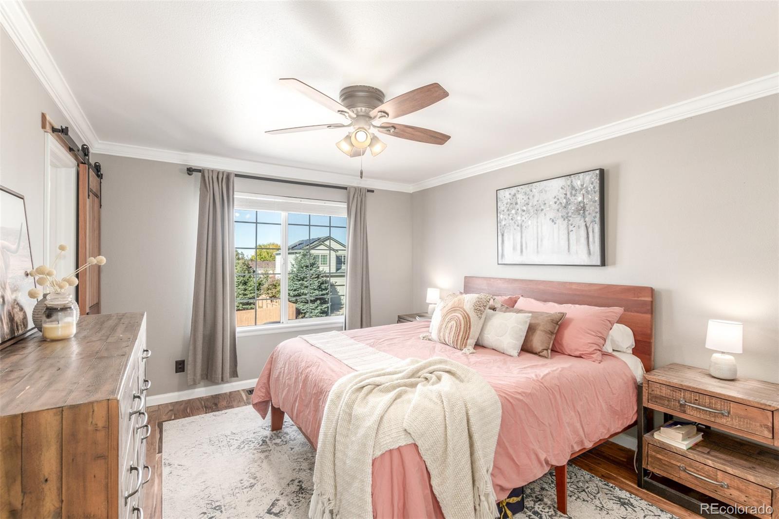 4864 Parsons Way Castle Rock, CO 80104 - Photo 15 of 50 a bedroom with a large bed and a chandelier