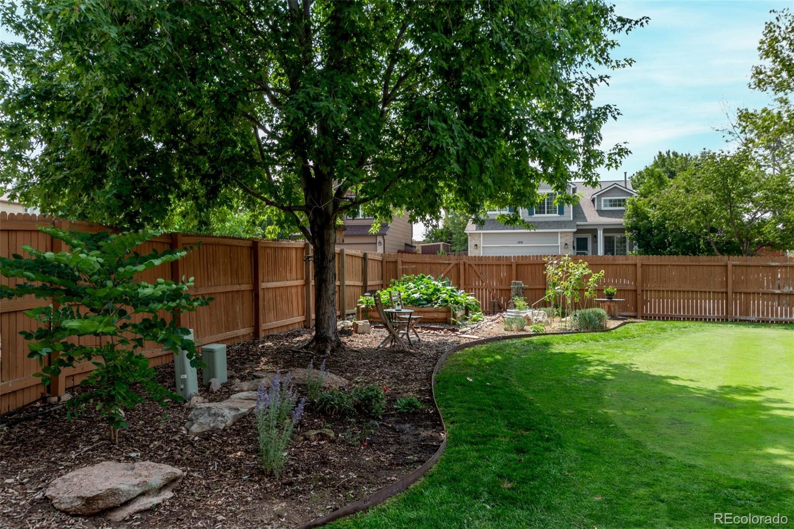 4864 Parsons Way Castle Rock, CO 80104 - Photo 36 of 50 a view of a backyard with table and chairs potted plants and large tree