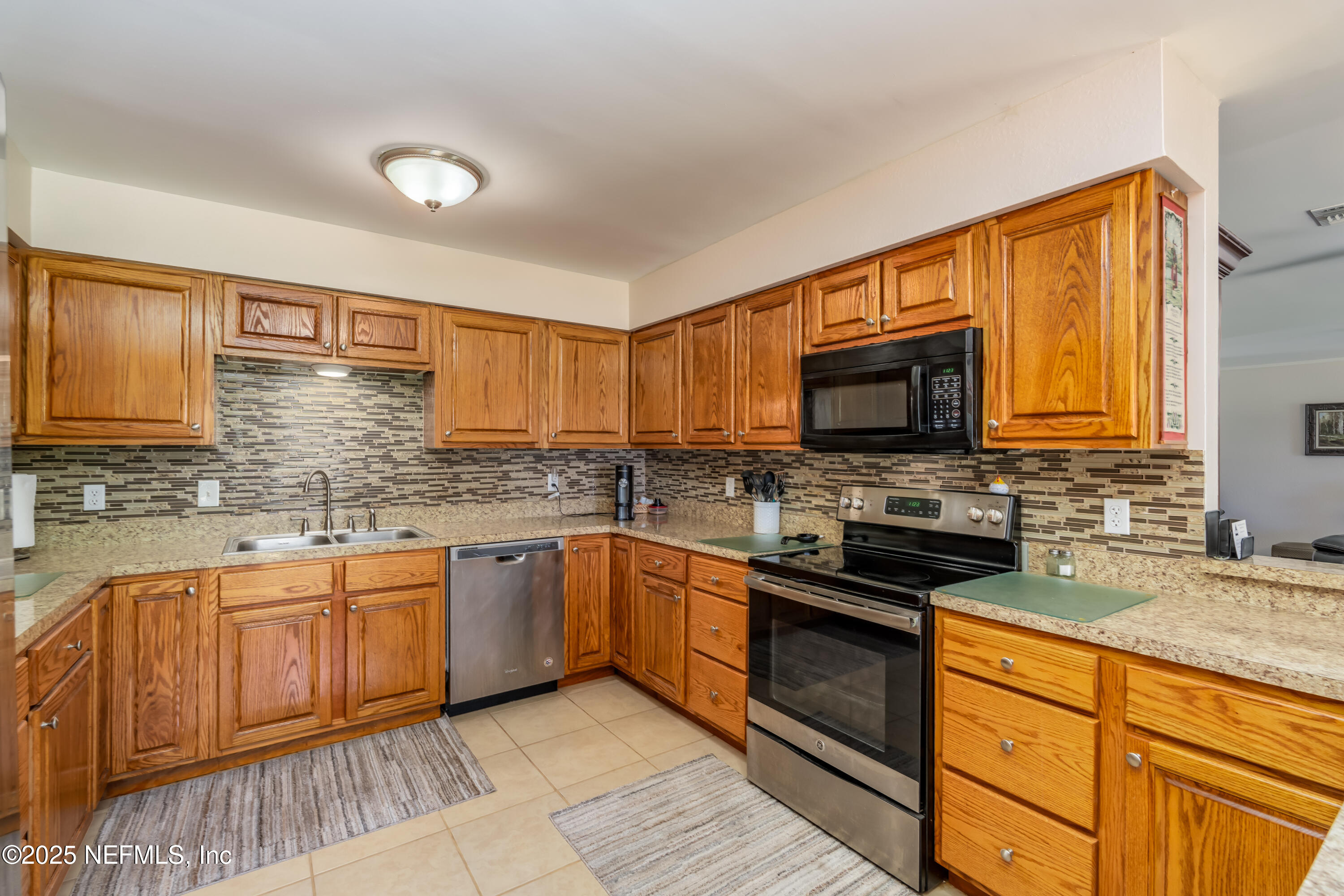 8048 County Line Road Melrose, FL 32666 - Photo 29 of 40 a kitchen with stainless steel appliances granite countertop wooden cabinets a stove top oven a sink and dishwasher