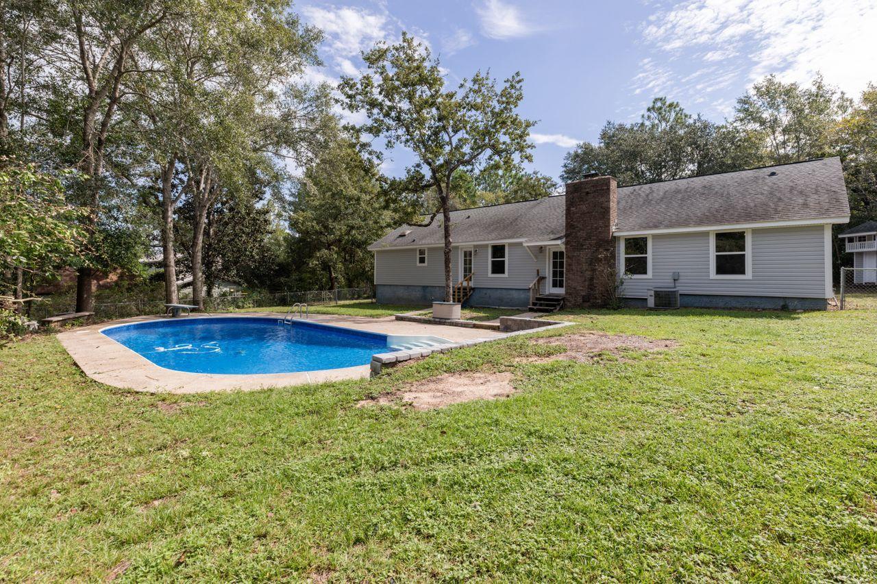 6130 Beasley Road Crestview, FL 32536 - Photo 24 of 28 a view of a house with swimming pool and a yard