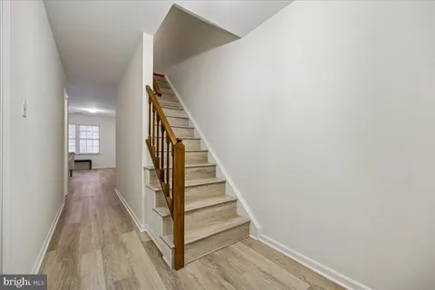 a view of a hallway with wooden floor and entryway