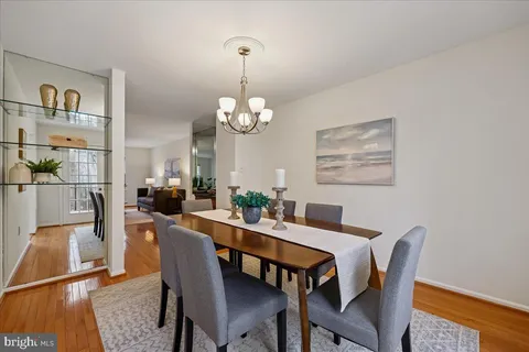 a view of a dining room with furniture a chandelier and wooden floor