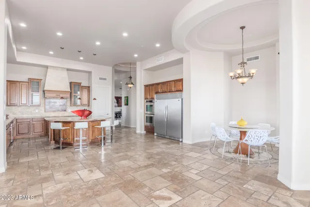 a kitchen with stainless steel appliances kitchen island granite countertop a refrigerator and a sink