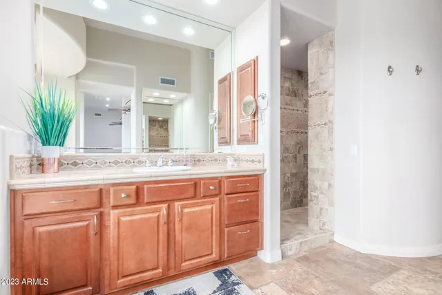 a bathroom with a sink a toilet and a large mirror