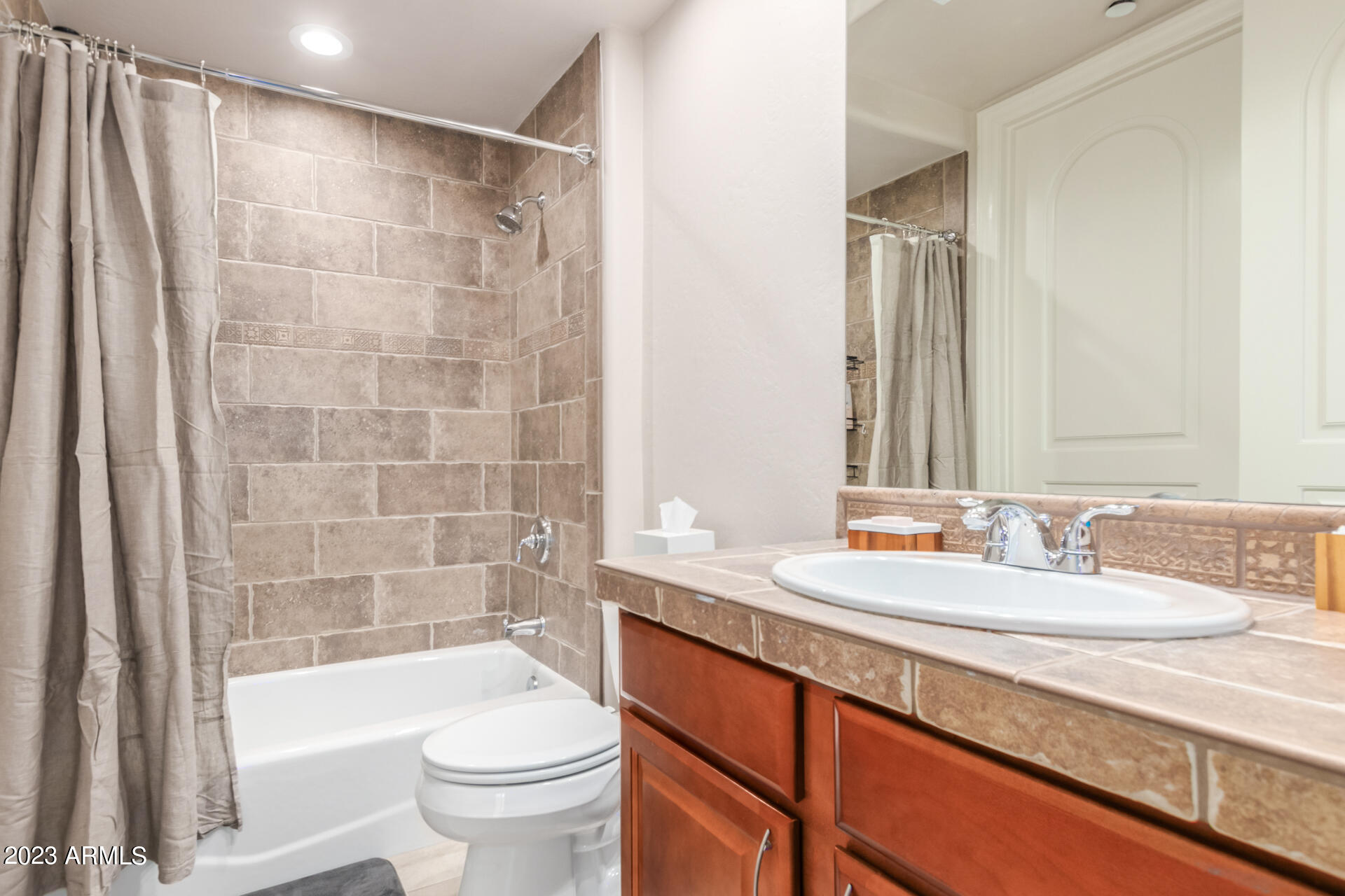 14234 North 27th Place Phoenix, AZ 85032 - Photo 30 of 66 a bathroom with a sink a toilet and a large mirror