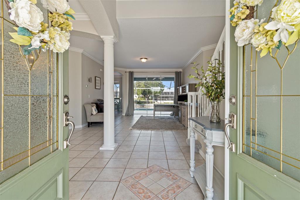 703 Bunker View Drive Apollo Beach, FL 33572 - Photo 6 of 49 a hallway with a dining table and a chandelier