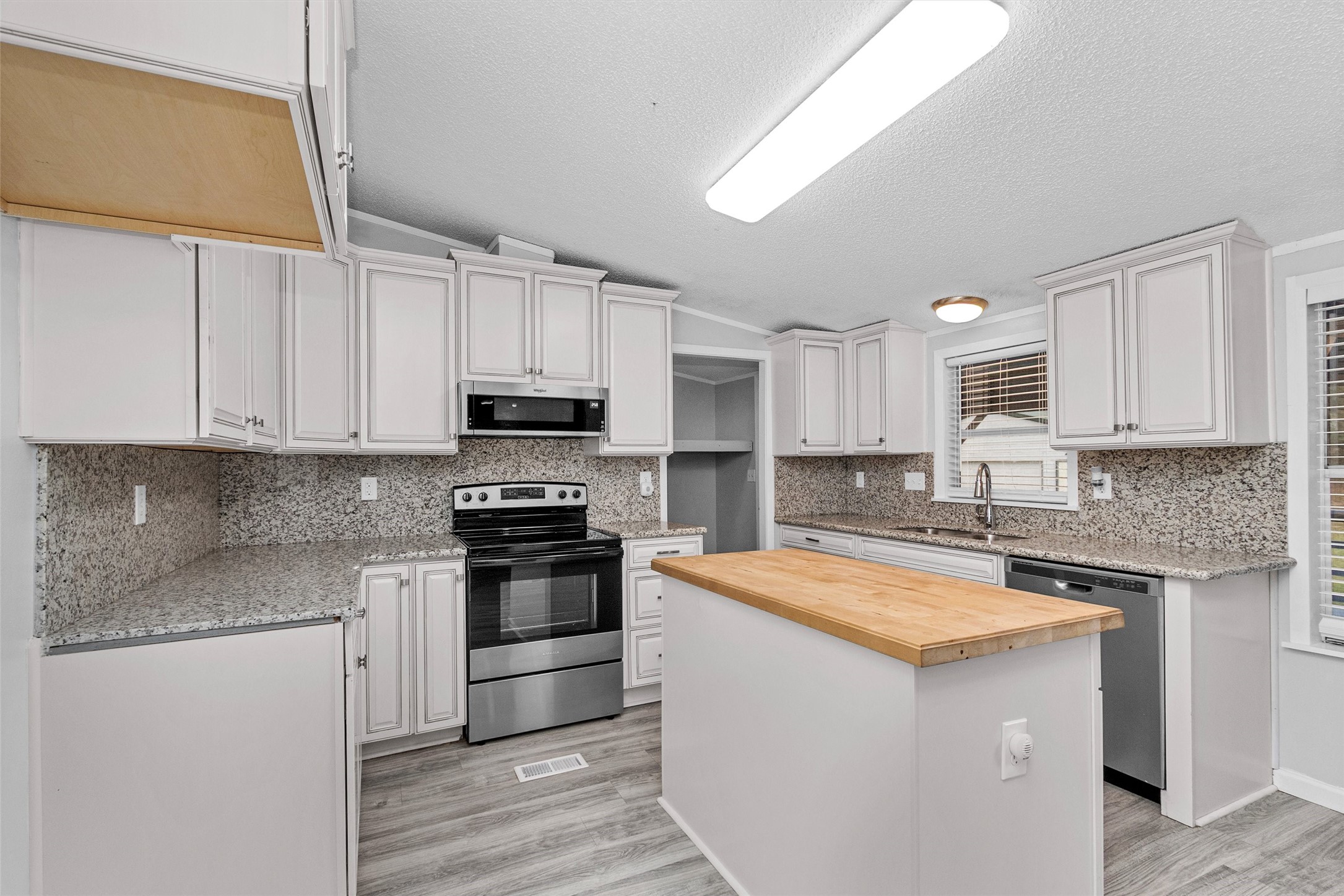 4621 Price Road Montgomery, TX 77316 - Photo 12 of 50 a kitchen with stainless steel appliances granite countertop a sink stove and refrigerator