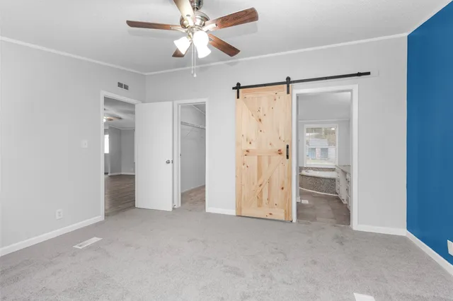 an empty room with closet and a ceiling fan