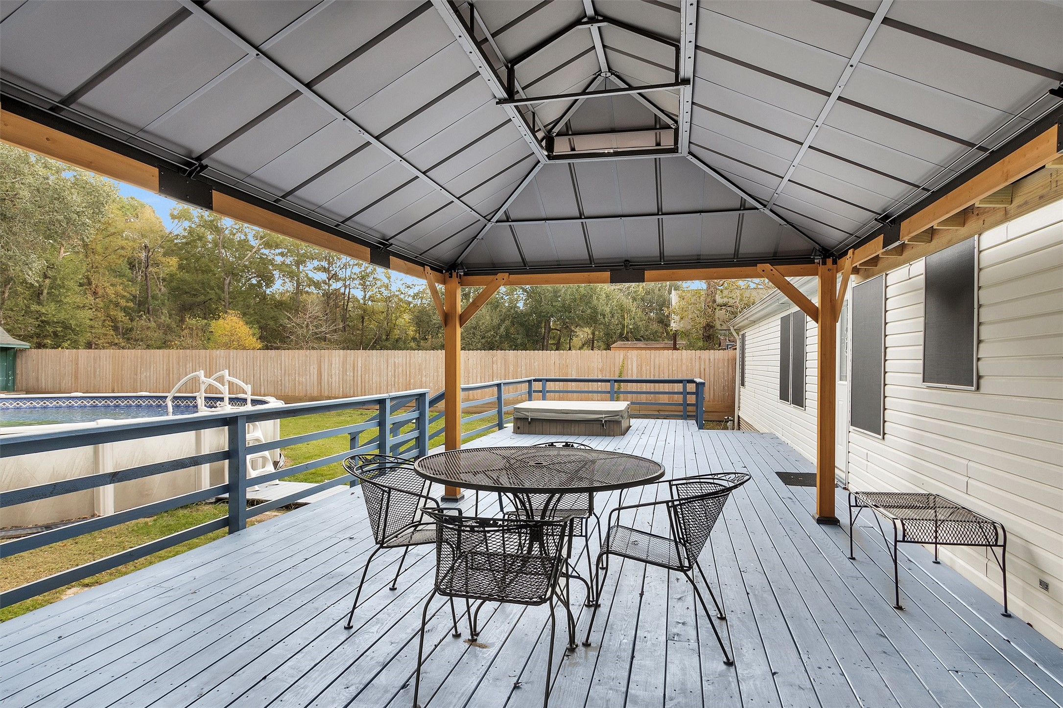 4621 Price Road Montgomery, TX 77316 - Photo 34 of 50 a patio with wooden floor a yard a table and chairs