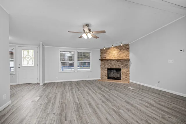 wooden floor fireplace and windows in an empty room