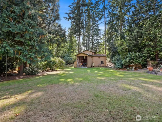 a view of a house with backyard and trees