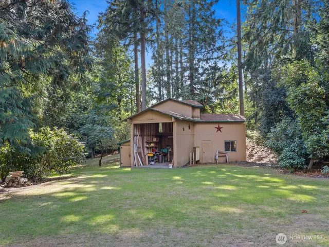 a backyard of a house with plants and large trees