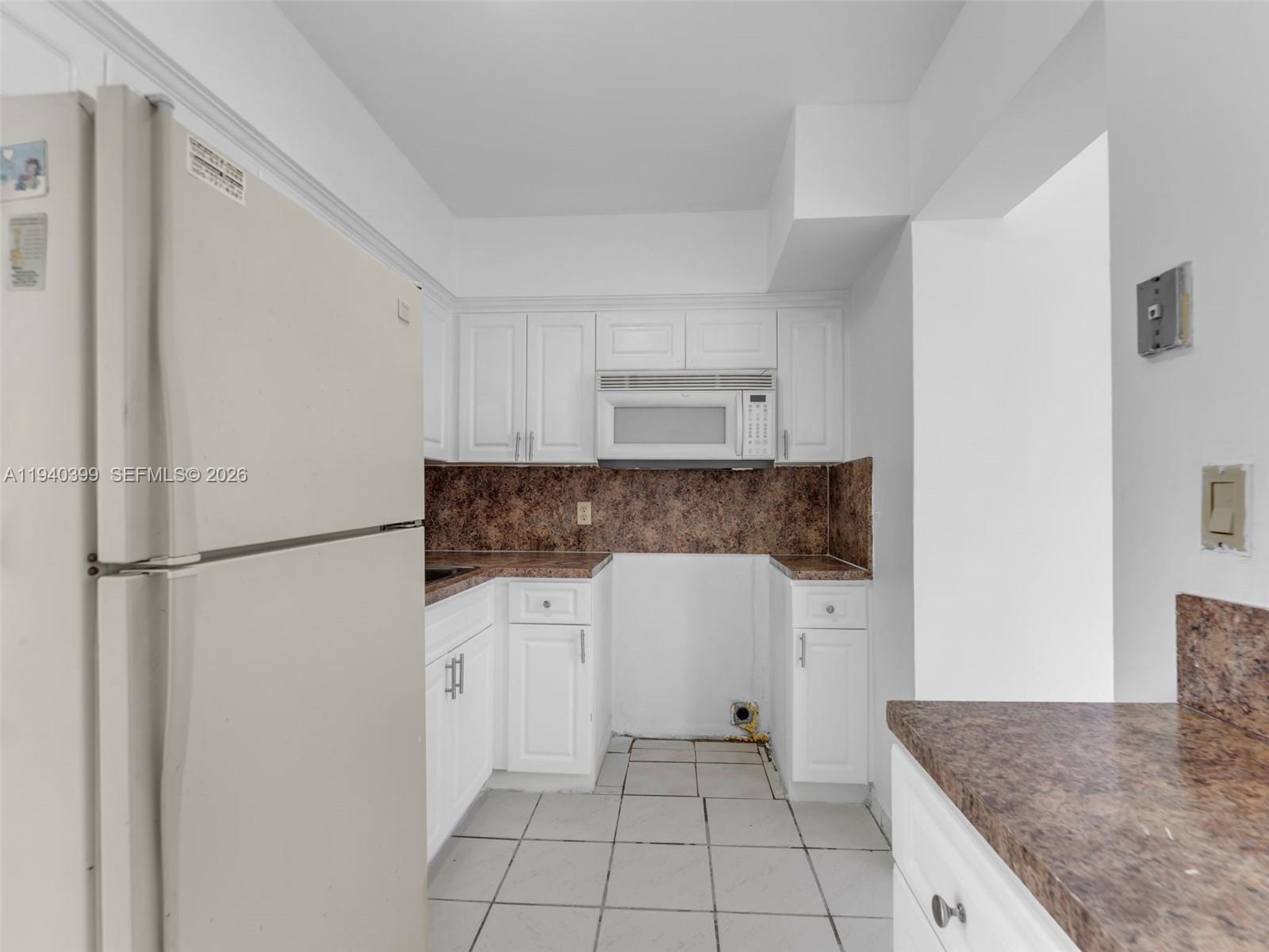 1811 Southwest 97th Terrace, Unit 2 Miramar, FL 33025 - Photo 12 of 29 a kitchen with a refrigerator and white cabinets