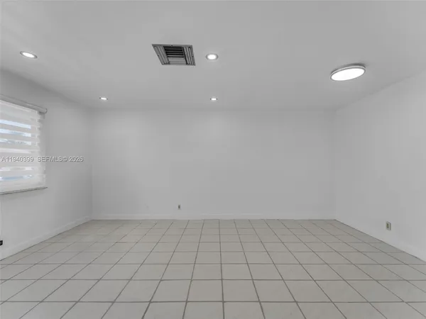 a kitchen with white cabinets and refrigerator