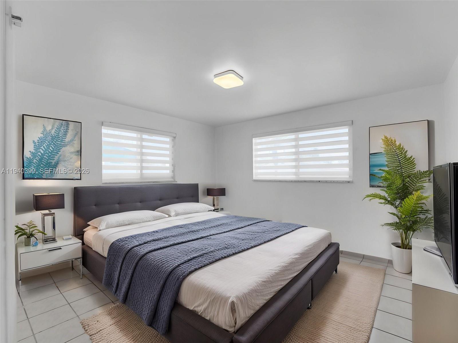 1811 Southwest 97th Terrace, Unit 2 Miramar, FL 33025 - Photo 22 of 29 a bedroom with a large bed and a potted plant
