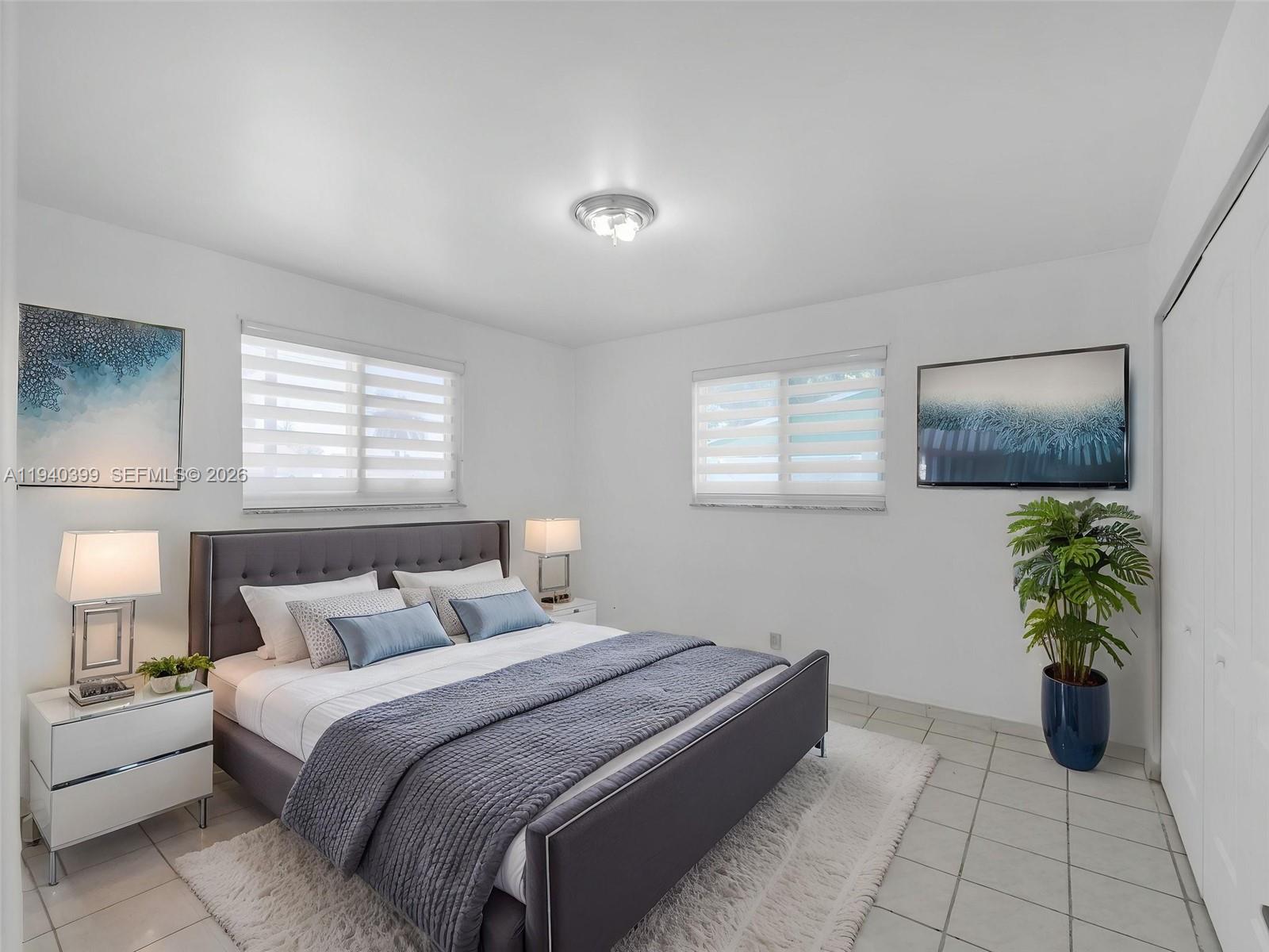 1811 Southwest 97th Terrace, Unit 2 Miramar, FL 33025 - Photo 25 of 29 a bedroom with a bed and a potted plant