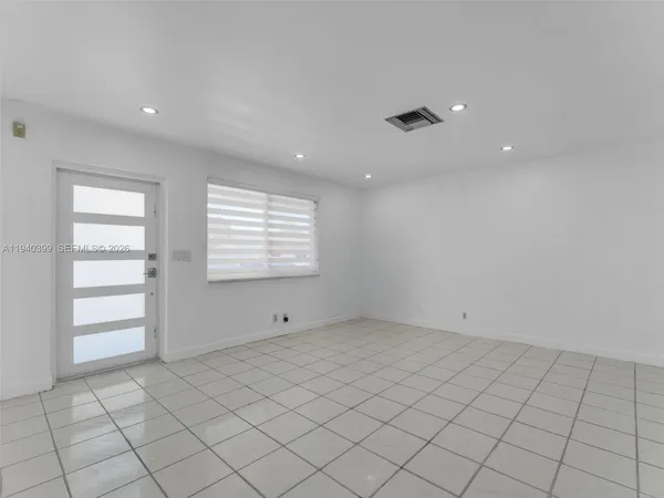 an empty room with kitchen view