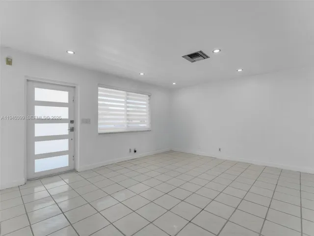 an empty room with kitchen view