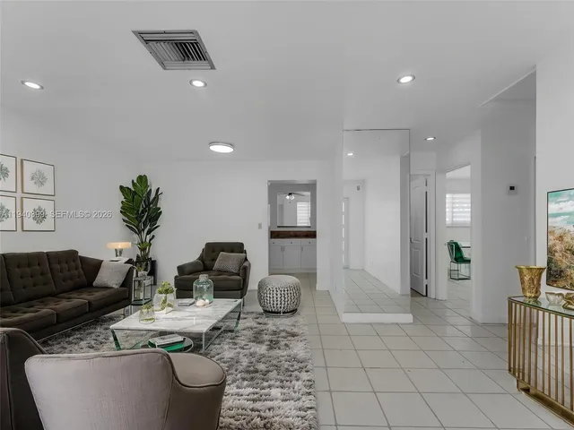 a view of a refrigerator in kitchen and an empty room