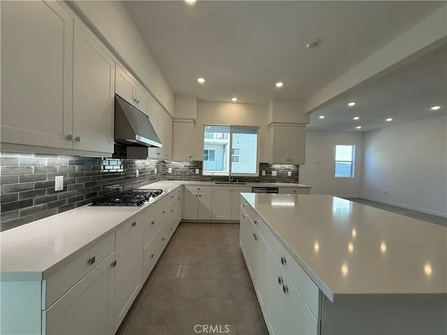 a large kitchen with stainless steel appliances granite countertop a sink a stove a microwave and a refrigerator