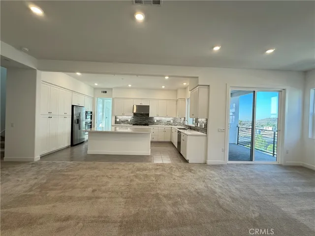 a view of kitchen with refrigerator and windows