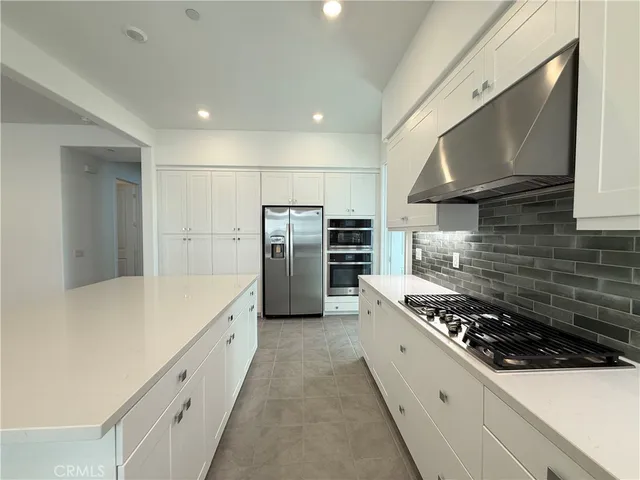 a kitchen with refrigerator a stove and a sink