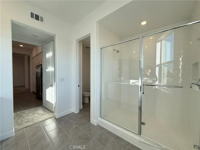 a bathroom with a shower and a glass door