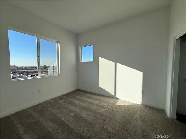 an empty room with windows and closet