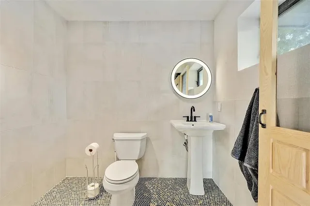 a bathroom with a toilet a sink and a mirror
