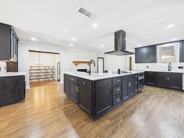 a kitchen with stainless steel appliances a sink and a wooden floor