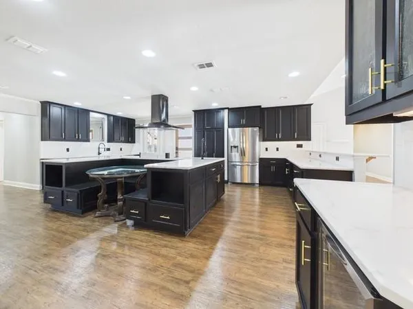 a kitchen with kitchen island cabinets a sink a counter and a center island