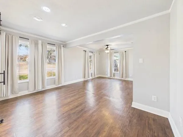 a view of a livingroom with wooden floor and a ceiling fan
