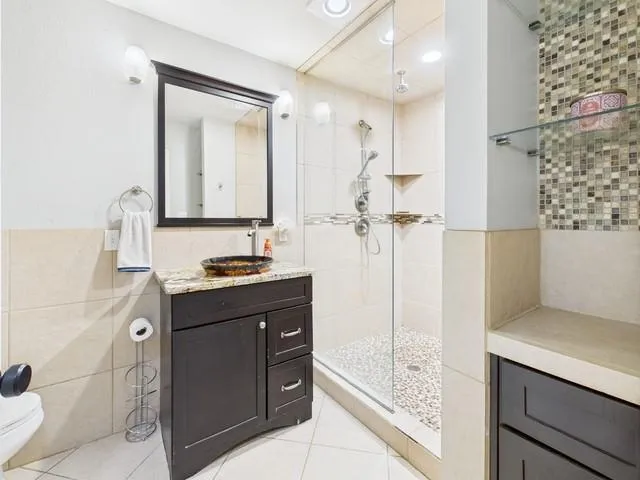 a very nice looking bedroom with a large bed a chandelier and a dresser