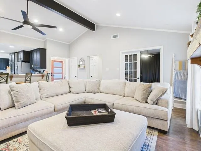 a living room with furniture and a wooden floor