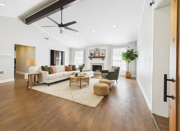 a living room with furniture and a wooden floor