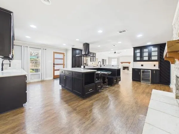 a large kitchen with stainless steel appliances granite countertop a large counter top a sink a stove and a refrigerator