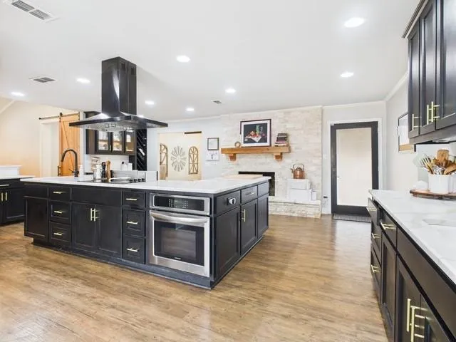 a kitchen with stainless steel appliances kitchen island granite countertop a stove and cabinets