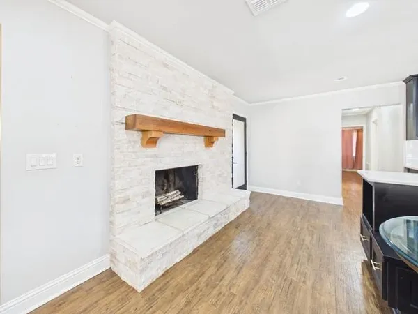 a living room with a fireplace and wooden floor