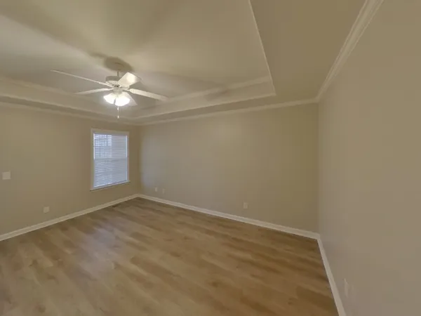 an empty room with a ceiling fan and window