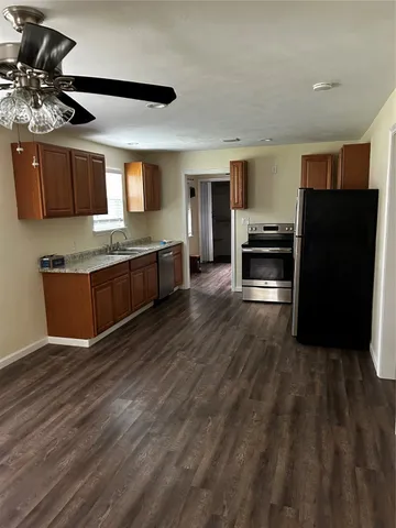 a kitchen with stainless steel appliances wooden floor and refrigerator