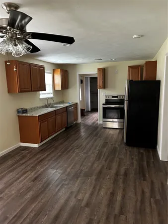 a kitchen with stainless steel appliances wooden floor and refrigerator