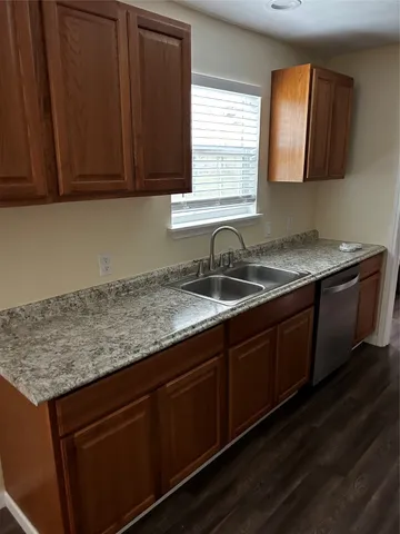 a kitchen with granite countertop a sink cabinets and window
