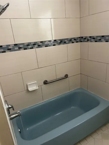 a bath tub sitting next to a shower