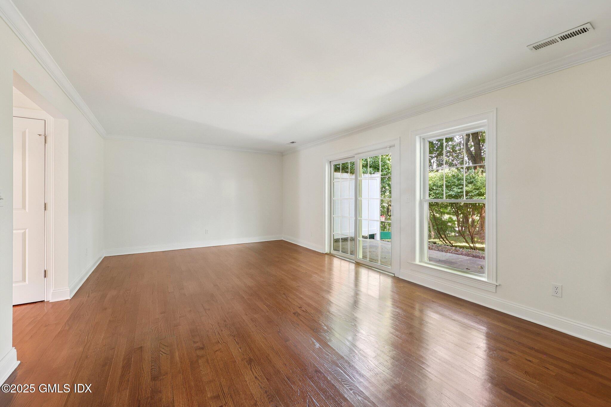 251 Weaver Street, Unit 1C Greenwich, CT 06831 - Photo 12 of 29 a view of an empty room with wooden floor and a window