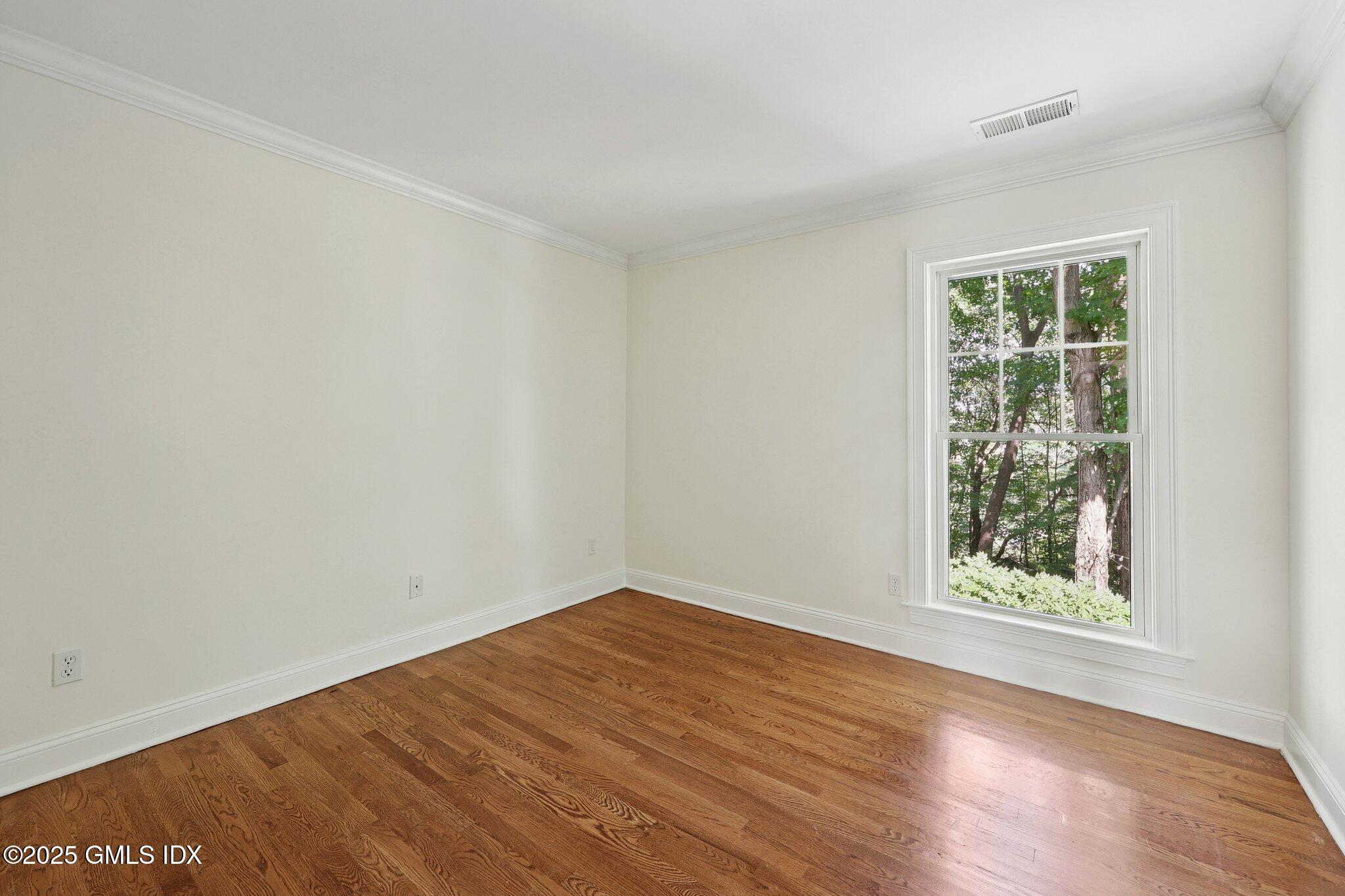 251 Weaver Street, Unit 1C Greenwich, CT 06831 - Photo 13 of 29 an empty room with wooden floor and windows