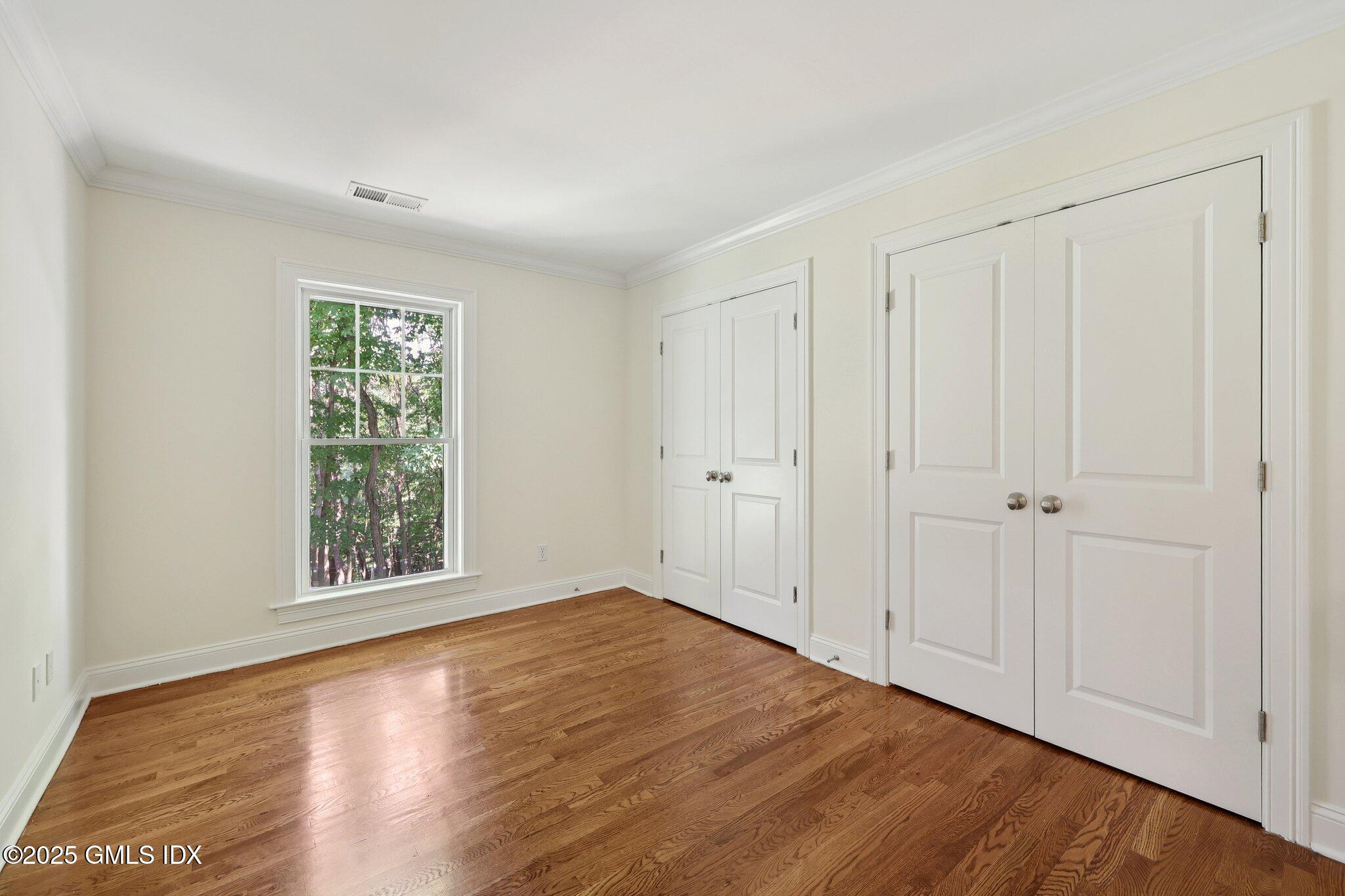 251 Weaver Street, Unit 1C Greenwich, CT 06831 - Photo 16 of 29 a view of an empty room with wooden floor and a window